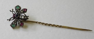 A gold stick pin in the form of an insect, the wings set precious stones