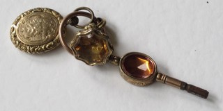 A gilt metal watch key, a gilt metal locket and a seal