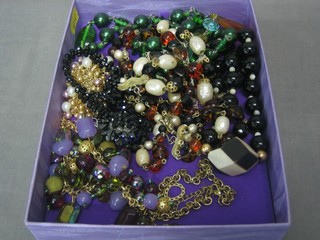 A purple box with various costume jewellery, beads etc