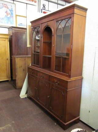 A Georgian style mahogany bookcase on cabinet, the upper section with moulded and dentil cornice, the centre fitted a niche flanked by a pair of cupboards enclosed by astragal glazed panelled doors, the base fitted 3 long drawers above cupboards, raised on bracket feet 57"