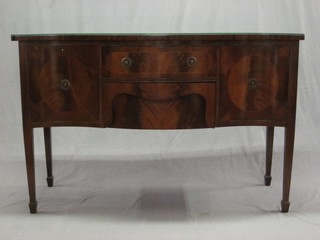 A  Georgian style mahogany sideboard of serpentine outline fitted 2 long drawers flanked by a pair of cupboards, raised on square tapering supports ending in spade feet 56"