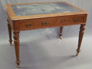 A Victorian oak writing table with inset writing surface, the base fitted 2 drawers raised on turned supports ending in brass caps and castors 14"
