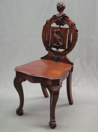 A Victorian mahogany hall chair with solid seat and carved shield back, raised on cabriole supports