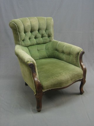 An Edwardian mahogany show frame armchair upholstered in green buttoned material, raised on cabriole supports