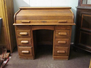 A honey oak D shaped kneehole pedestal roll top desk, fitted 1 long drawer above 6 short drawers 44"