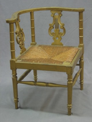 A Victorian gilt painted corner chair with lyre shaped slat back and woven cane drop in seat, raised on turned supports