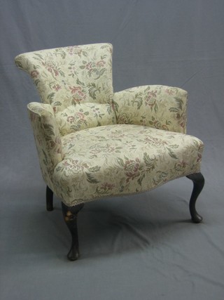An Edwardian shaped mahogany armchair upholstered in tapestry material and raised on cabriole supports