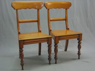 A pair of 19th Century bleached mahogany bar back hall chairs with shaped mid rails and solid seats, raised on turned supports