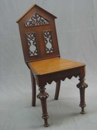 A Victorian mahogany hall chair with pierced backs and solid seat, raised on turned supports (back loose)