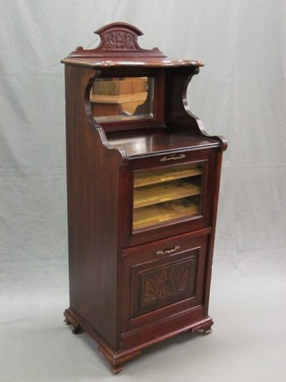 An Edwardian carved walnut music cabinet with raised mirrored back, the base fitted 2 compartments, enclosed by a glazed panelled and carved panelled door 18"