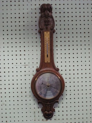 An aneroid barometer and thermometer by Weathermaster,  contained in a carved oak wheel case