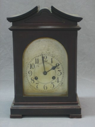 An Edwardian 8 day bracket clock with 6 1/2" arched silvered dial and Arabic numerals contained in a mahogany case