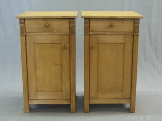 A pair of Continental stripped and polished pine bedside cabinets each fitted a drawer above a cupboard 16"
