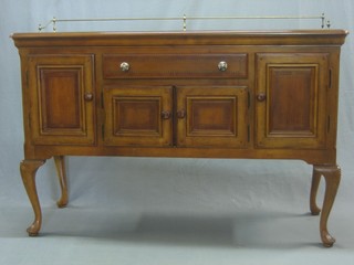 A Continental style inlaid mahogany sideboard with raised bar to the back, fitted 1 long drawer above a double cupboard flanked by a pair of cupboards, raised on cabriole supports 55"