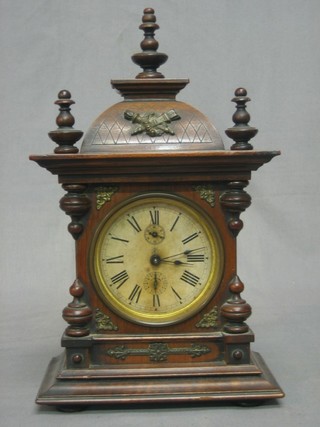 A 19th Century Continental alarm clock with paper dial and Roman numerals contained in a walnut case