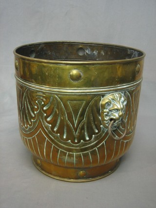 A circular embossed brass twin handle jardiniere/log basket