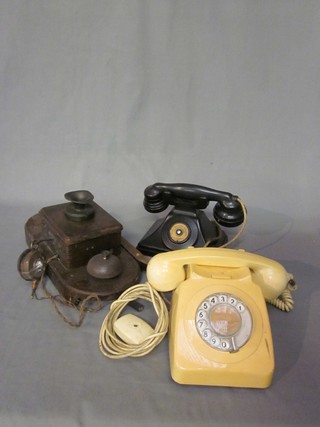 A GEC wooden wall mounting internal telephone, a Bakelite ditto. and a yellow plastic dial telephone