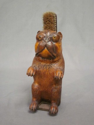 A German carved wooden brush holder in the form of a dog, base fitted a musical box movement 10"