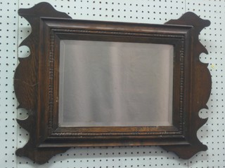A rectangular bevelled plate mirror contained in an oak frame 24"