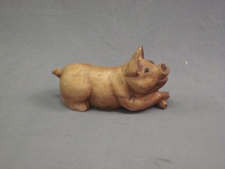 A carved wooden figure of a reclining pig 17"