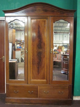 An Edwardian inlaid mahogany double wardrobe with moulded cornice, the centre section fitted a rectangular inlaid panel flanked by a pair of arched bevelled plate mirrored doors, the base fitted a 2 long drawers, raised on a platform base 60"
