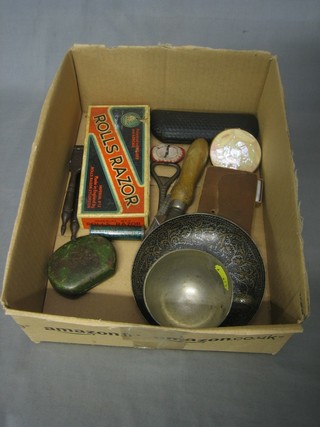 An Eastern metal cup and saucer, a pair of WWII gas mask spectacles, a Rolls razor and other curios