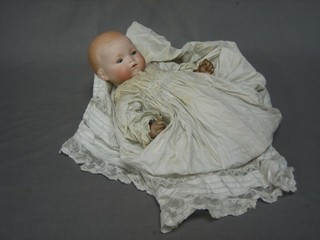 A 19th Century German porcelain headed doll with open and shutting eyes and closed mouth, the head incised Germany