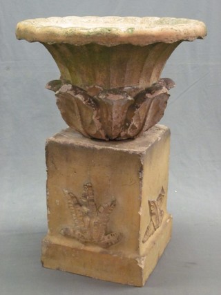 A handsome circular terracotta coloured garden urn with acanthus leaf decoration, raised on a square base (some chips) 33" overall