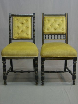 2 Victorian ebonised chairs upholstered in gold material, raised on turned supports with H framed stretcher