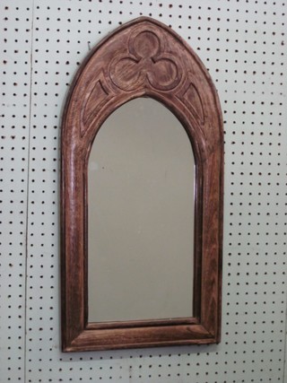 A mirror contained in a Gothic style carved frame 24"