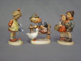 A Goebel figure of a girl with watering can (head f and r), do. boy mounting a stile (chipped) and do. standing boy and girl