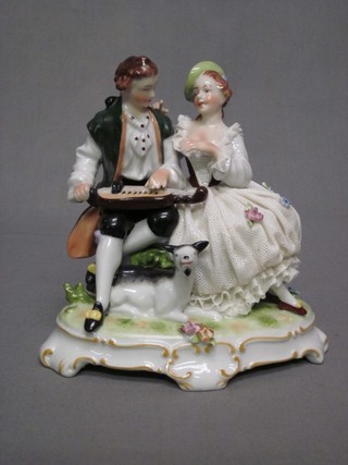 A 20th Century Continental porcelain figure group of a musician with crinoline lady 6"
