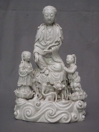 A blanc de chine porcelain figure of a standing Eastern Deity with 2 attendants, the reverse with impressed seal mark 12"