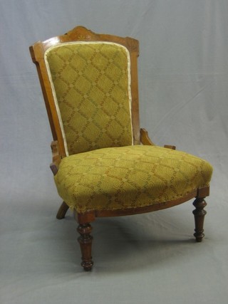 A Victorian inlaid walnut nursing chair with upholstered seat and back, raised on turned supports
