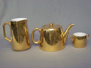 A Royal Worcester gilt glazed teapot, matching cream jug and sugar bowl