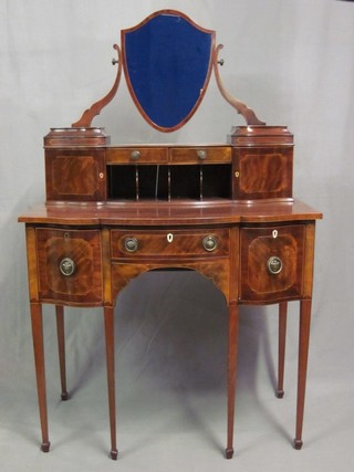 A handsome 19th Century Sheraton style mahogany dressing table, the raised upper section with shield shaped mirror, the base fitted 2 drawers and pigeon holes flanked by a pair of cupboards, the base fitted 1 long drawer flanked by 2 short drawers and raised on square tapering supports ending in spade feet 36"