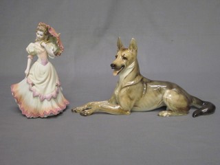 A Hutchenreuther porcelain figure of a reclining Alsatian 13" and a Coalport figure of a standing lady 8"