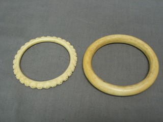 A carved ivory bangle and 1 other