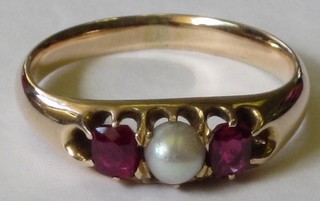 A lady's gold dress ring set a pearl supported by 2 rubies