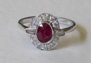 A lady's 18ct white gold dress ring set an oval cut ruby with baguette cut diamonds to the shoulders and surrounded by diamonds, approx 0.5/1.5ct