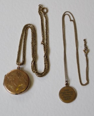 A gold pendant hung on a fine gold chain and a gold locket hung on a gold chain