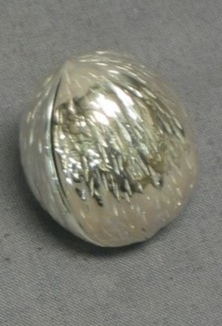 A silver trinket box in the form of a walnut
