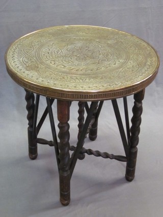 A circular Benares brass tray raised on a spiral turned oak stand 24" 