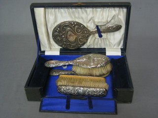 A 4 piece silver backed dressing table set with pair of hair brushes, pair of clothes brushes and a hand mirror, Birmingham 1926