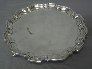 A silver plated salver with bracketed border, raised on scrolled supports 15"