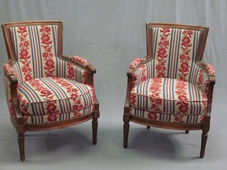 A pair of mahogany framed armchairs with upholstered seats, raised on turned and fluted supports