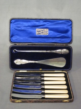 A set of 6 silver plated tea knives and a silver handled shoe horn and butter hook, cased