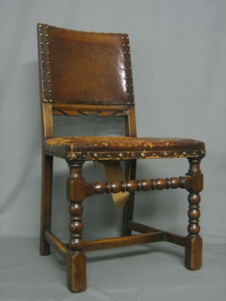 A set of 4 oak dining chairs, the seats and backs upholstered in leather and raised on turned and block supports