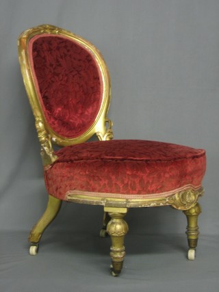 A Victorian gilt painted nursing chair with upholstered seat and back, raised on turned supports