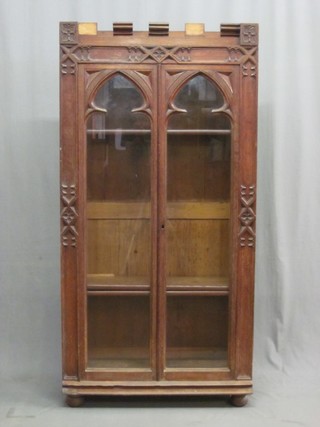 A Victorian oak Gothic style bookcase, the interior fitted adjustable shelves enclosed by arched panelled doors 31"